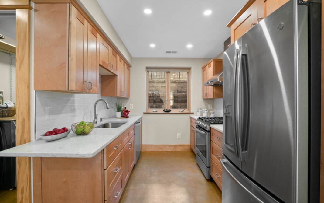 A kitchen with wooden cabinets and stainless steel appliances

Description automatically generated